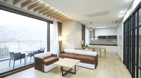 A luxury hotel suite with a large window showing a stunning panoramic ocean view.